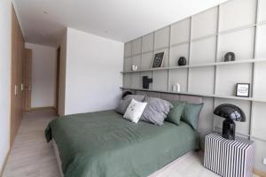 - une chambre avec un grand lit vert et des étagères dans l'établissement Departamento Epic-Quito, à Hacienda Carolina