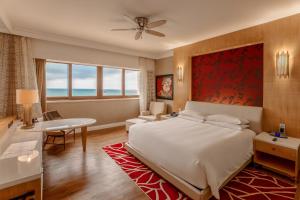 a bedroom with a bed and a desk and a table at InterContinental Grand Ho Tram in Ho Tram