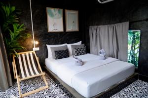 ein Schlafzimmer mit zwei Betten und einem Stuhl in der Unterkunft แอทเกาะล้านรีสอร์ท in Ko Sak