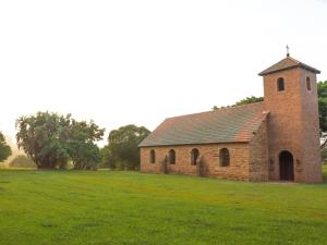 une vieille église en briques dans un champ d'herbe dans l'établissement Fountainhill Estate Accommodation, à Wartburg