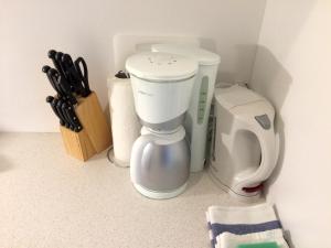 a white coffee maker sitting on a counter next to a knife block at Apartment Westside in Regensburg