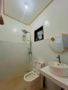 een badkamer met een wastafel, een toilet en een spiegel bij A-rena Homestay in General Luna +28 foto's