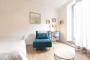 a bedroom with a blue chair and a table at Au Petit Sommet - OursBlanc APPARTEMENT CENTRE VILLE 30m2 in Modane