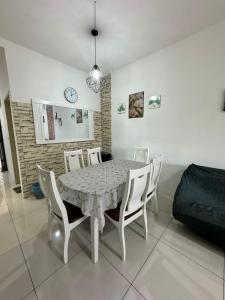 a dining room with a table and white chairs at AYAAN BLOSSOM BUDGET HOMESTAY FREE WiFi and Netflix in Tanah Rata
