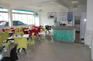 ein Restaurant mit Tischen, gelben Stühlen und einer Theke in der Unterkunft Santorini Hotel in Santarém