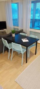 a dining table and chairs in a living room at Apartment Kauppatie, neljälle hengelle in Laihia