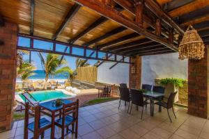 a patio with a table and chairs and a pool at Makani Vichayito in Vichayito