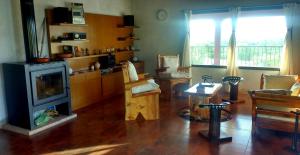 a living room with a fireplace and a table at Habitación privada en casa rural, vistas Uritorco in Capilla del Monte