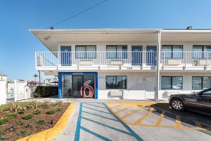 un bâtiment avec une voiture garée devant lui dans l'établissement Motel 6-Mcallen, TX, à McAllen