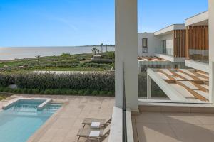 una vista de la playa desde el balcón de una casa en Serenity Waves Villa 5, en Lárnaca
