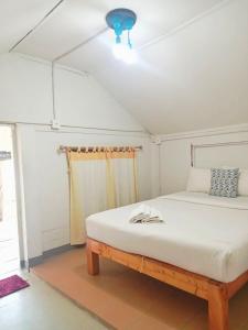 a bed in a room with a ceiling fan at Seasonsamed Resort in Ao Phutsa