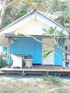 a blue house with two white chairs on a porch at Seasonsamed Resort in Ao Phutsa +9 photos
