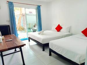 a room with two beds and a table and a window at Seasonsamed Resort in Ao Phutsa