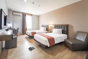 Postel nebo postele na pokoji v ubytování Grand Kangen Hotel Urip Sumoharjo