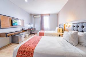 Postel nebo postele na pokoji v ubytování Grand Kangen Hotel Urip Sumoharjo
