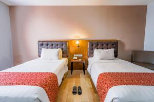 Postel nebo postele na pokoji v ubytování Grand Kangen Hotel Urip Sumoharjo