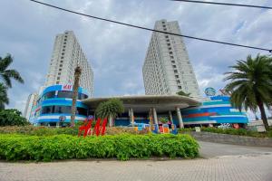 two tall buildings with red chairs in front of a building at Warm and Cozy Studio at Cinere Bellevue Suites Apartment By Travelio in Depok