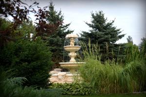 a fountain in the middle of a garden at Hotel Marco Płońsk Szkolna 115 in Płońsk +22 photos