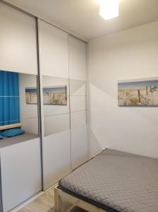 sypialnia z białymi ścianami i łóżkiem w obiekcie Apartament Kapitalny przy porcie w Kołobrzegu z rowerownią i placem zabaw w Kołobrzegu