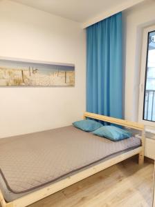 sypialnia z łóżkiem i oknem w obiekcie Apartament Kapitalny przy porcie w Kołobrzegu z rowerownią i placem zabaw w Kołobrzegu