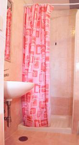 a bathroom with a pink shower curtain and a sink at Hotel Euro Quiris in Rome