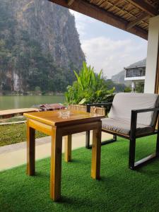a table and a chair and a view of a lake at Amanda Riverside in Nongkhiaw