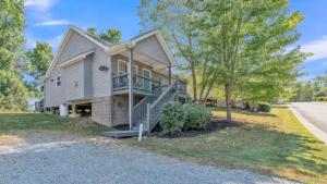 a house with a staircase in front of a road at Whiskey River Lake Retreat in Taylorsville