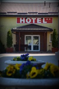 a hotel with yellow flowers in front of it at Hotel Marco Płońsk Szkolna 115 in Płońsk