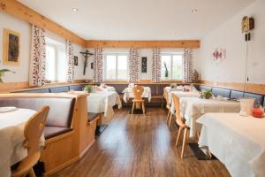 a dining room with tables and chairs and windows at Oberwirtshof in Rifiano