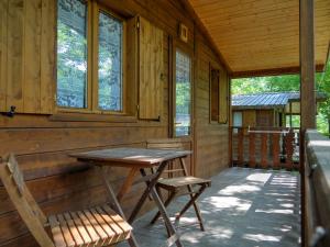a table and two chairs on the porch of a cabin at Stura River Village RAFTING in Gaiola