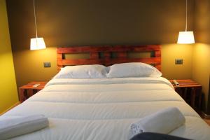 a bedroom with two beds with white sheets and two lights at B&B Miro Centro Catania in Catania