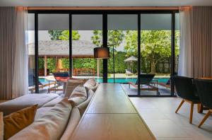 a living room with a couch and a pool at Villa De Time - The Luxury Private Pool Villa in Pattaya South