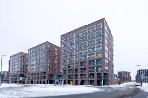 two tall buildings on a street in the snow at Prestigious Apartment & Enjoy Waterfront Living in Tampere
