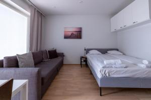 a living room with two beds and a couch at Prestigious Apartment & Enjoy Waterfront Living in Tampere
