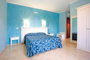 1 dormitorio con cama y pared azul en Hotel Aquila, en Aprilia