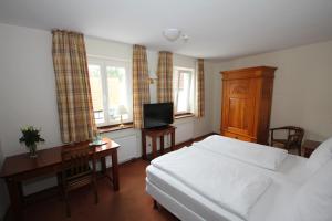 a bedroom with a bed and a desk and a television at Hotel Drei Linden in Lünen