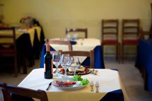 a table with a plate of food and a bottle of wine at Hotel Aquila in Aprilia