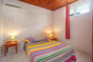 a bedroom with a bed with two lamps on two tables at Horizon Créole - Climatisé avec piscine partagée in Les Trois Ponts