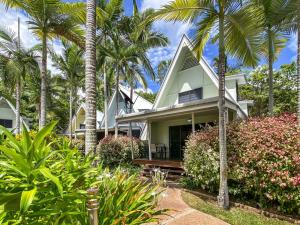 耐莉湾Canopy Chalet 10的一栋门前有棕榈树的房子