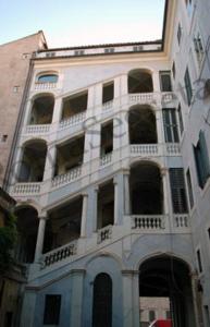 a tall white building with a lot of windows at Appartamento Piazza Farnese in Rome