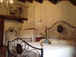 a bedroom with a bed with a wrought iron headboard at Agriturismo Il Casalone in Badia Tedalda