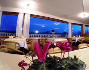 ソプラボルツァーノにあるホテル ポスト ビクトリアの海の景色を望むレストラン(テーブル付)