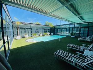 a building with a swimming pool and two lounge chairs at Halfway House Hotel in Kimberley