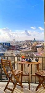 a table and chairs on a balcony with a view of a city at Belvedere Quartieri Napoli in Naples