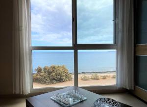 a large window with a view of the beach at Appartamento Sinestesia Oceanica in Puerto del Rosario