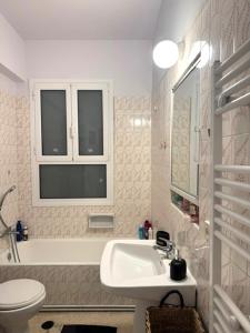 a white bathroom with a sink and a toilet at Xenia in Athens