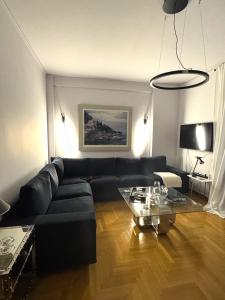 a living room with a black couch and a glass table at Xenia in Athens