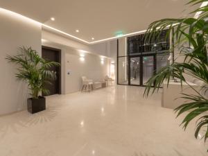 an empty lobby with plants and a table and chairs at The Samirah Luxury Residences in Elliniko in Athens +253 photos