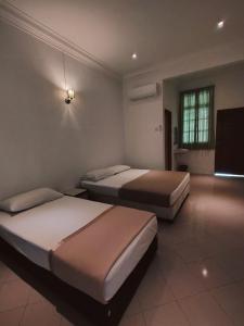 a room with two beds and a television in it at Pearl Villa 5 Bedroom Unit 7 in Port Dickson