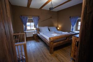sypialnia z dużym drewnianym łóżkiem w pokoju w obiekcie Krčma Hotel U Císařské Cesty w mieście Branišovice